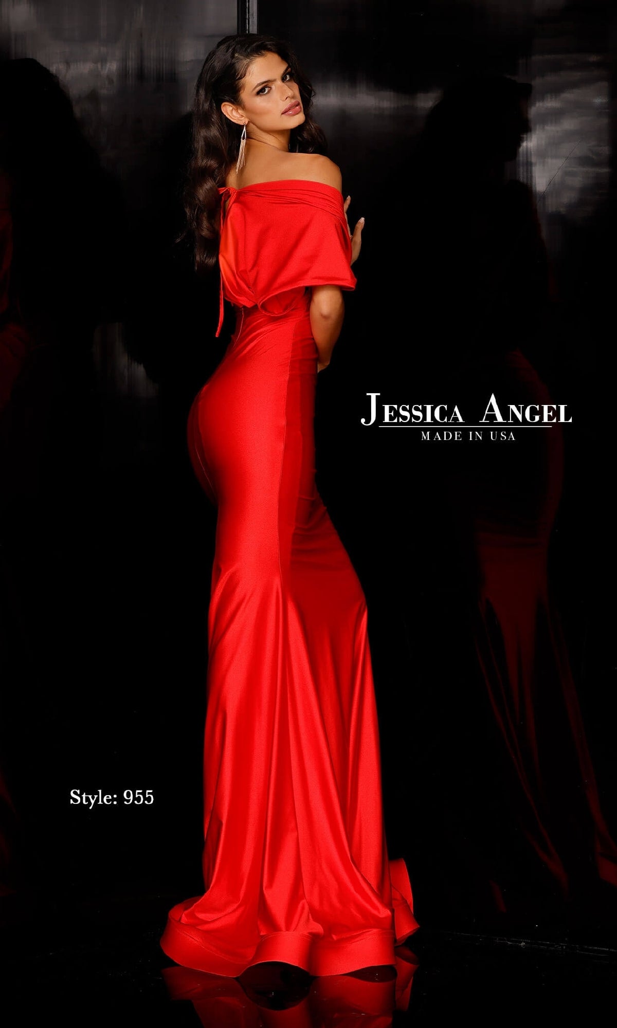 Woman wearing Jessica Angel 955 short sleeve long prom dress in red, posing against a black background. Text reads “Jessica Angel Made in USA” and “Style: 955.”.